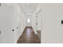 Bright hallway featuring wood flooring, white walls, and multiple doors leading to various rooms at 19714 Highclere Ln, Sheridan, IN 46069