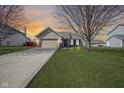 Inviting single-story home with a lush green lawn and a long driveway at sunset at 2167 Meridian Springs Ln, Greenfield, IN 46140