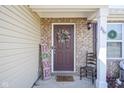 A welcoming front porch featuring a decorative wreath, a wooden chair, and stylish decor at 2167 Meridian Springs Ln, Greenfield, IN 46140