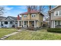 Two-story home with a red roof, tan siding, a welcoming front porch, and a well-manicured front lawn at 3416 Guilford Ave, Indianapolis, IN 46205
