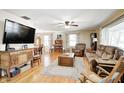 Bright, airy living room featuring hardwood floors, a large TV, and comfortable seating, perfect for relaxing or entertaining at 412 Tulip Dr, Mooresville, IN 46158
