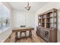 Stylish home office featuring wood floors, a decorative accent wall, and a classic wooden desk and shelving unit at 4905 Andover Pkwy, Westfield, IN 46062