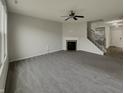 Spacious living room featuring a fireplace, ceiling fan and staircase leading to the second floor at 5371 Hibiscus Dr, Plainfield, IN 46168