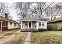 Inviting two-story home featuring a welcoming porch with a swing, complemented by a brick pathway at 5432 Winthrop Ave, Indianapolis, IN 46220