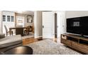 Cozy living space with a plush rug, television, and an open doorway leading to the dining area at 5432 Winthrop Ave, Indianapolis, IN 46220