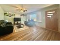 Cozy living area featuring hardwood flooring, a ceiling fan, and a large window with natural light at 6346 Shelby St, Indianapolis, IN 46227