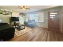 Inviting living room with hardwood floors, a ceiling fan, and comfortable black leather furniture at 6346 Shelby St, Indianapolis, IN 46227