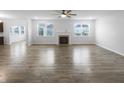 Spacious living room featuring hardwood floors, a fireplace, and large windows for ample natural light at 6457 Flag Stop Dr, Whitestown, IN 46075