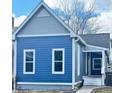 Detailed view of a blue two-story home featuring gray accents, a small porch, and a tidy walkway at 1206 Dawson St, Indianapolis, IN 46203