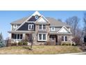 Charming two-story home featuring stone and siding exterior, a front porch, and manicured landscaping at 13702 Beam Ridge Dr, Fishers, IN 46055