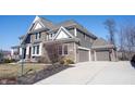 Beautiful home with a three car garage, stone accents, and a well-maintained driveway at 13702 Beam Ridge Dr, Fishers, IN 46055