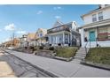 Street view showcasing the house with a balcony and landscaped front yard, blending seamlessly into a friendly neighborhood at 1413 S East St, Indianapolis, IN 46225