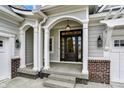 Inviting front porch featuring stone steps and decorative columns and hanging lantern at 15745 Market Center Dr, Carmel, IN 46033