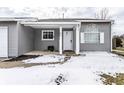 Inviting front porch with snow, and white door, creating a welcoming entrance at 163 Country Wood Dr, Whiteland, IN 46184