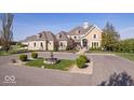 Elegant home with a circular driveway, mature landscaping, and a charming water fountain at 2766 S Honey Creek S Rd, Greenwood, IN 46143