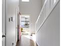 Bright entryway featuring hardwood floors, white staircase, and a glimpse of the exterior through the open door at 459 Dekalb Dr, Westfield, IN 46074