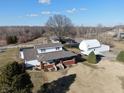 Inviting home with a brick porch, white siding, outbuildings, and a well-maintained yard at 5420 W Goeller W Rd, Columbus, IN 47201