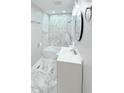 Modern bathroom with marble-style tile shower, new vanity, lighting, and a contemporary mirror at 5546 Marilyn Rd, Indianapolis, IN 46226