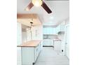 Bright, white kitchen with a butcher block island, white cabinetry, subway tile backsplash, and modern lighting at 5546 Marilyn Rd, Indianapolis, IN 46226