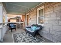 Relaxing front porch with stone walls, comfortable seating, and stylish rug creating an inviting outdoor space at 6225 Indianola Ave, Indianapolis, IN 46220