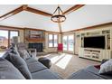 Bright living room featuring a cozy fireplace, large windows, beamed ceilings, and comfortable seating with modern décor at 8329 Hill Gail Dr, Indianapolis, IN 46217