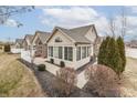 A home's exterior shows an abundance of windows, manicured shrubbery, and a partial white fence at 10329 Gateway Dr, Indianapolis, IN 46234