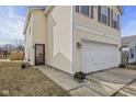 Side view of a yellow home with a two-car garage and a brown front door at 10613 Glenayr Dr, Camby, IN 46113