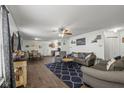 Inviting living room featuring hardwood floors, ceiling fan, and comfortable seating arrangement at 10613 Glenayr Dr, Camby, IN 46113