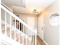 Bright entryway features a staircase with white banisters, hardwood floors, and modern light fixture at 10867 Pine Bluff Dr, Fishers, IN 46037