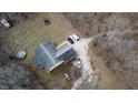 Aerial shot of a secluded home with a long driveway, two vehicles, trampoline and surrounded by mature trees at 1195 Hinson Rd, Martinsville, IN 46151