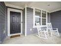 Inviting front porch with rocking chairs and a view of a well maintained lawn at 12504 Castle Pine Dr, Noblesville, IN 46060