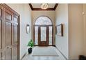 Elegant foyer featuring a decorative front door, tile flooring, and wood trim at 16 W Greyhound Pass, Carmel, IN 46032