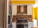 Modern kitchen with stainless steel appliances, mosaic backsplash, and light gray cabinets at 2333 Villa Ave, Indianapolis, IN 46203