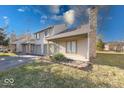 Charming condo with attached garage and front yard is surrounded by green grass and mature trees at 2552 Spring Hill Ct, Indianapolis, IN 46268
