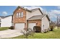 Attractive two-story home boasts a brick exterior, two-car garage, and mature landscaping at 2879 Bluewood Way, Plainfield, IN 46168