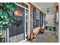 Inviting covered front porch with seasonal decor and brick accents, offering curb appeal at 2912 Tuscarora Ln, Indianapolis, IN 46217