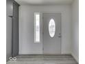 Bright entryway showcasing modern flooring, white walls, and a front door with decorative glass at 32 Downing Dr, Trafalgar, IN 46181