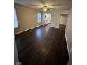 Living room with a ceiling fan and window view with wood-look flooring at 3837 Candle Berry Dr, Indianapolis, IN 46235