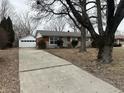 Traditional brick home featuring an attached garage and well-maintained landscaping at 4616 N Kenmore Rd, Indianapolis, IN 46226
