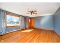 Bright living room featuring hardwood floors, a large window with curtains and a ceiling fan at 4812 Southview Dr, Anderson, IN 46013