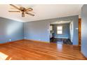 Inviting living room featuring hardwood floors, a ceiling fan, an open layout to the kitchen at 4812 Southview Dr, Anderson, IN 46013