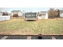 Large fenced-in backyard with an open grass area, storage shed, and a trampoline, ideal for outdoor enjoyment at 6830 Viola Ct, Indianapolis, IN 46237