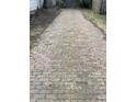 Long, charming driveway paved with bricks and moss leading to the detached garage at 7016 Evanston Ave, Indianapolis, IN 46220