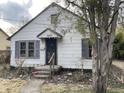 Charming bungalow-style home with white siding, shutters, and an inviting front porch entry at 7016 Evanston Ave, Indianapolis, IN 46220