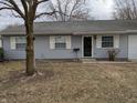 The house has a small yard and a classic front door with white trim at 8002 Bryan Dr, Indianapolis, IN 46227