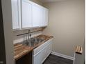 Renovated kitchen with stainless steel sink and white cabinets offers ample storage space at 8002 Bryan Dr, Indianapolis, IN 46227