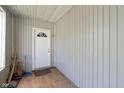 Enclosed entryway featuring white door with glass, light wood floors, and paneled walls at 818 S Grant St, Muncie, IN 47302
