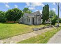 Neat gray home with lush lawn, showcasing its classic design and curb appeal from a corner view at 818 S Grant St, Muncie, IN 47302