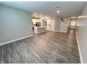 Open-concept living space with wood-look flooring and a modern kitchen with stainless steel appliances at 9616 Beckett St, Avon, IN 46123