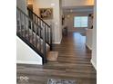 Open foyer with hardwood floors, leading to the living area and staircase with dark wood at 10218 Cliff Ln, Indianapolis, IN 46239
